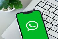 Foto: Ikon Aplikasi WhatsApp Pada Smartphone di Atas Laptop (Sumber: iStockphoto/Kurgenc)
